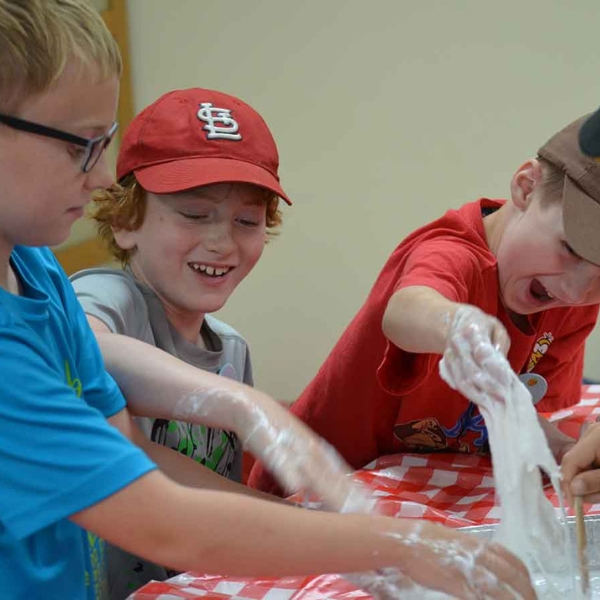 Children laughing while playing with slime