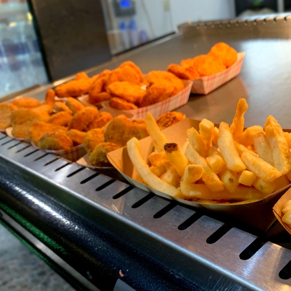 Close up of french fries and chicken nuggets in paper trays