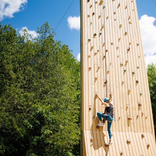 Woman scales climbing tower